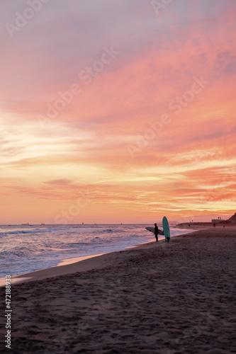 Puesta de sol en la playa de Altafulla con surfistas de fondo