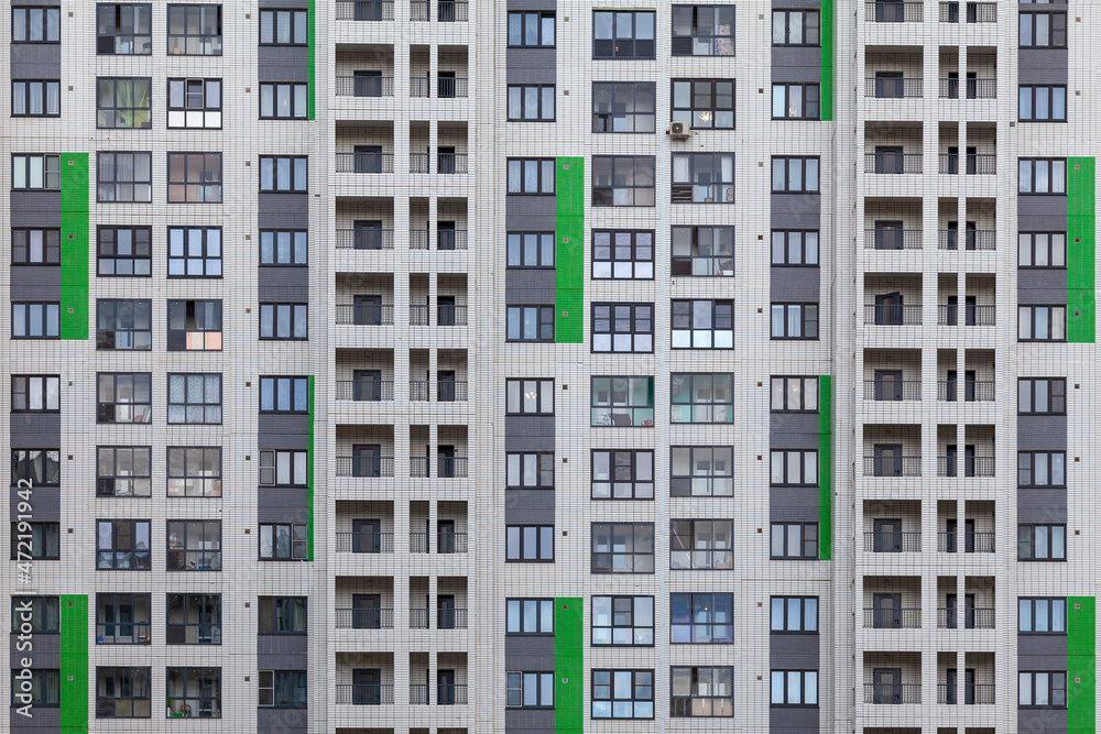 Background image - a white wall of a multi-storey building with green accents