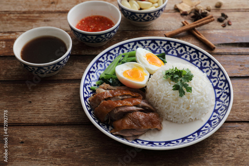 Local Thai food stewed pork leg on rice isolated in wood background