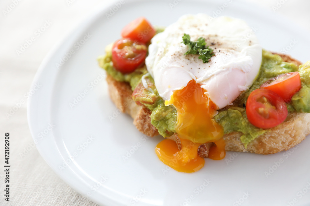 Poached eggs with avocado on toast in white background Poached eggs with avocado on toast in white background