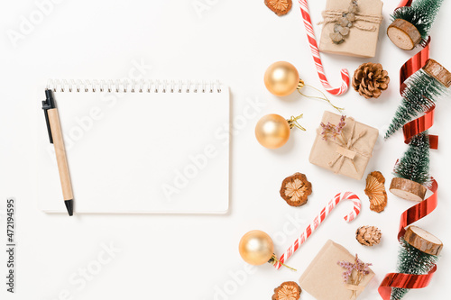 Minimal creative flat lay of winter christmas traditional composition and new year holiday season. Top view open mockup black notebook for text on white background. Mock up and copy space photography.