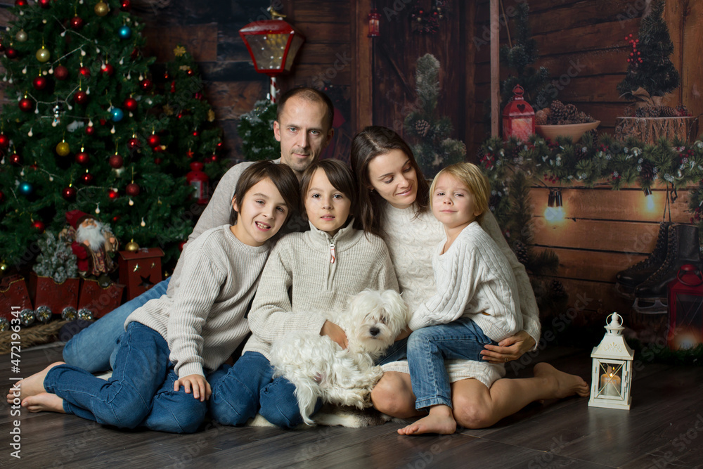 Happy family with children and pet dog, enjoying Christmas time together, celebrating