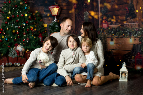 Happy family with children and pet dog, enjoying Christmas time together, celebrating