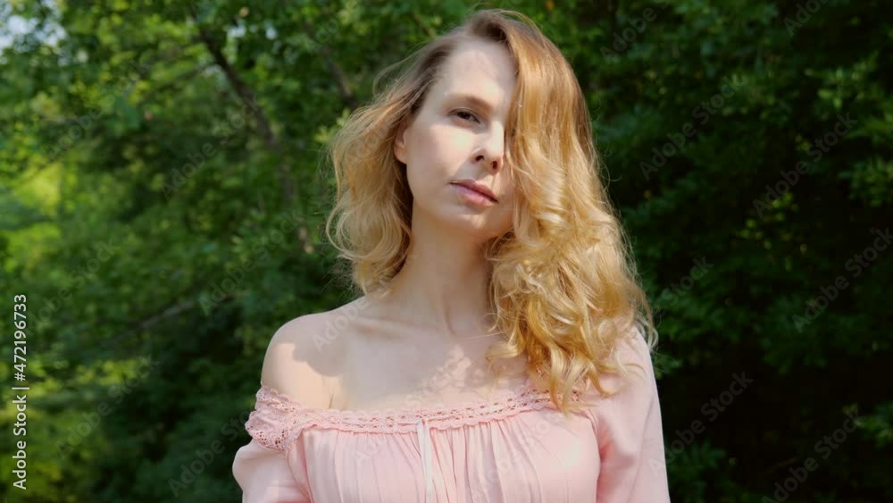 Portrait of a young woman near dark green foliage on nature in the forest. Slow motion 4K Portrait of a young woman near dark green foliage on nature in the forest. Slow motion 4K