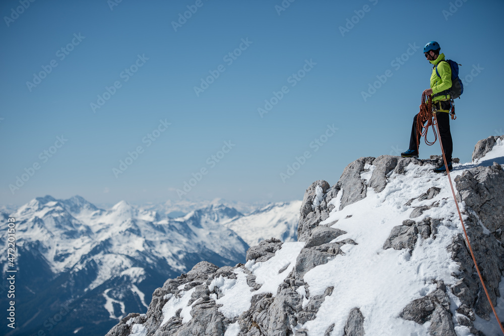 Junger Bergsteiger mit Kletterausrüstung im Schnee am Dachsteingletscher
