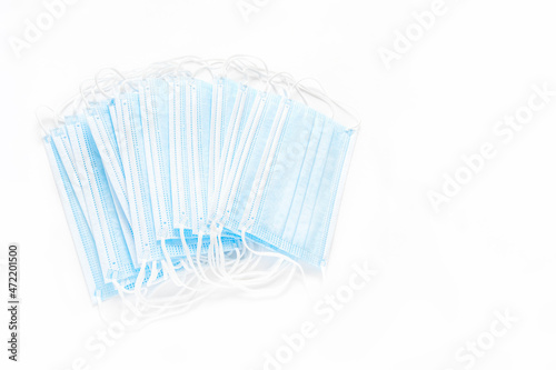 Medical disposable masks on a white background. Several medical masks lie on a white surface, flat lay, copyspace, top view