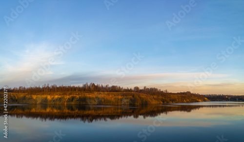The windless surface of the lake and the reflection of clouds on calm water. Leningrad region, Vsevolozhsk