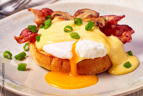 Egg Benedict with fried bacon and hollandaise sauce