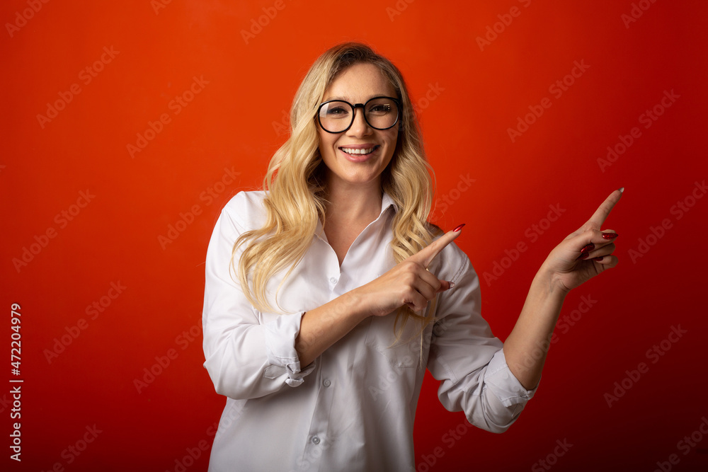attractive cute woman with glasses points to the side 