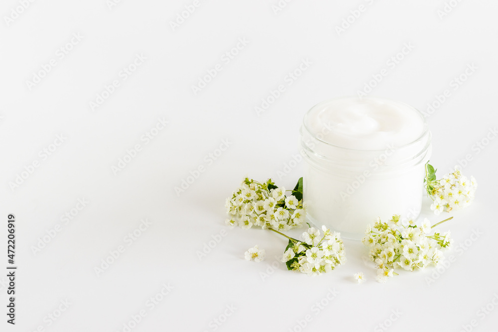 White blossoms flowers with skin cream in glass jar White blossoms flowers with skin cream in glass jar