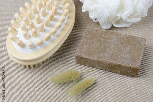 Means for delicate cleansing of the skin of the body - a wooden massage anti-cellulite brush, washcloth and handmade soap. Natural cosmetics made from environmentally friendly raw materials. Body care photo