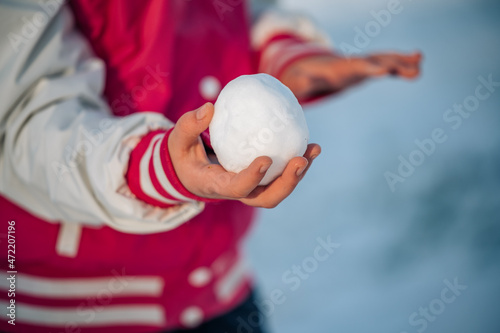 Little girl child holding snowball, close up