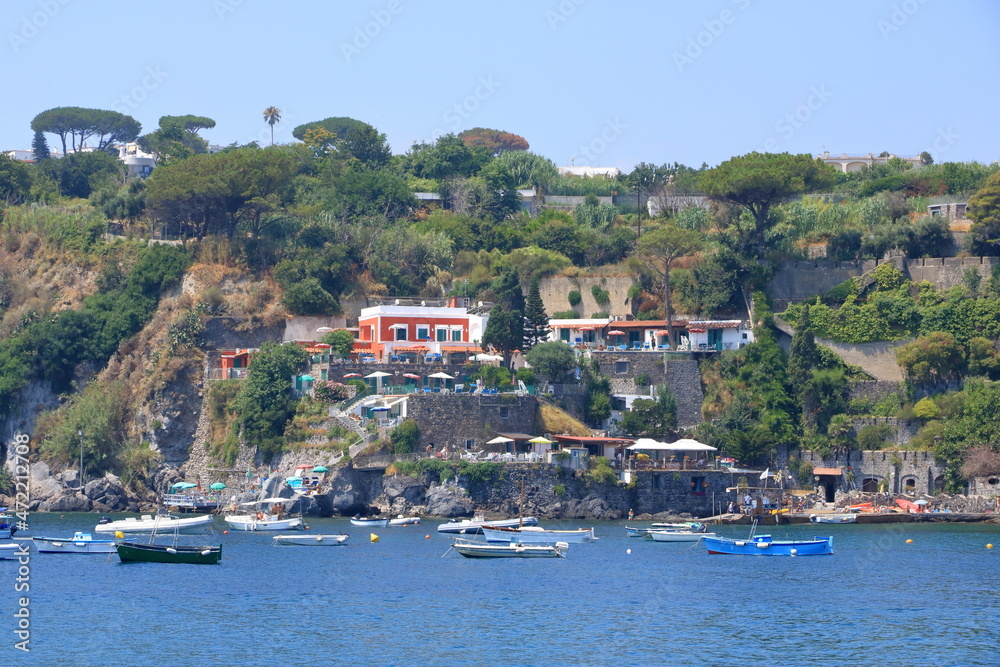 boats in front of the coast and beach in Ischia, Italy