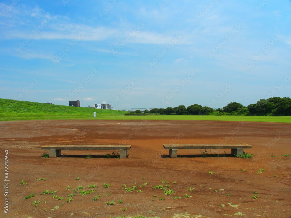 Obraz premium 梅雨晴れの平日の河川敷の整地された野球場風景