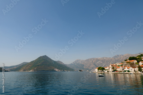 Boat is at the pier of Perast against the backdrop of mountains. Montenegro