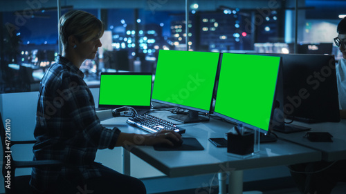 Night Office: Person with Disability Using Prosthetic Arm to Work on Green Screen Chroma Key Computer. Swift and Natural Use of Myoelectric Bionic Hand To Type Code for Software at Night. © Gorodenkoff