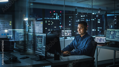 Night Office: Portrait of Handsome Indian Man in Working on Desktop Computer. Digital Entrepreneur Typing, Creating Modern Software, e-Commerce App Design, Programming. Stylish Authentic Person