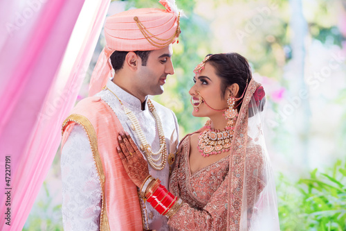 Portrait of an Indian wedding couple posing in front of camera for  photo album