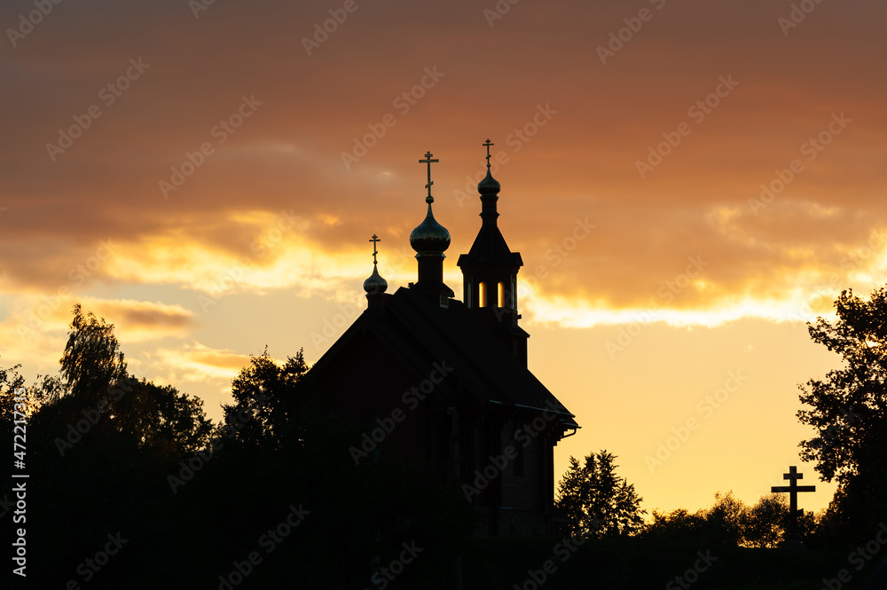 Church architecture. Christian church, domes, crosses, bell tower. Backlit photography at sunset.