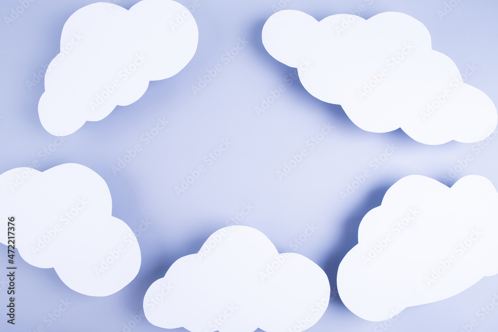 Blue background with frame made of paper white clouds