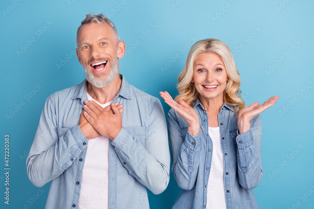 Photo of mature couple happy positive smile amazed excited surprised news isolated over blue color background Photo of mature couple happy positive smile amazed excited surprised news isolated over blue color background