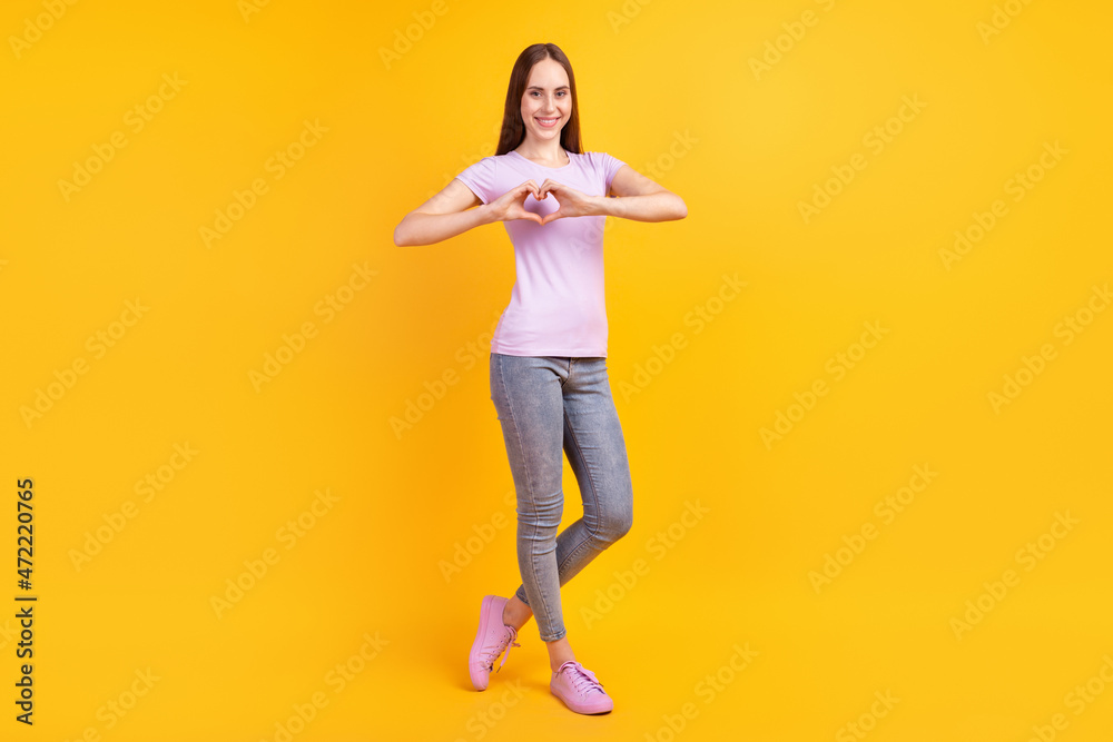 Full size photo of young attractive lady good mood show fingers heart symbol isolated over yellow color background Full size photo of young attractive lady good mood show fingers heart symbol isolated over yellow color background