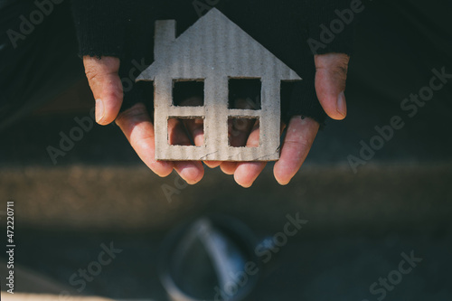 Cuadro en lienzo Poor tired depressed hungry homeless man holding a cardboard house