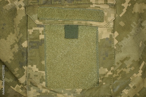 large green velcro patch on the pocket on the spotted military clothing