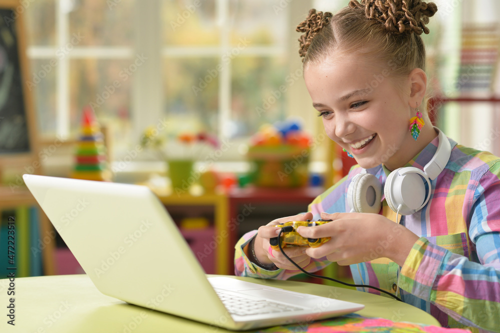 Cute little girl sitting at the table and playing Cute little girl sitting at the table and playing