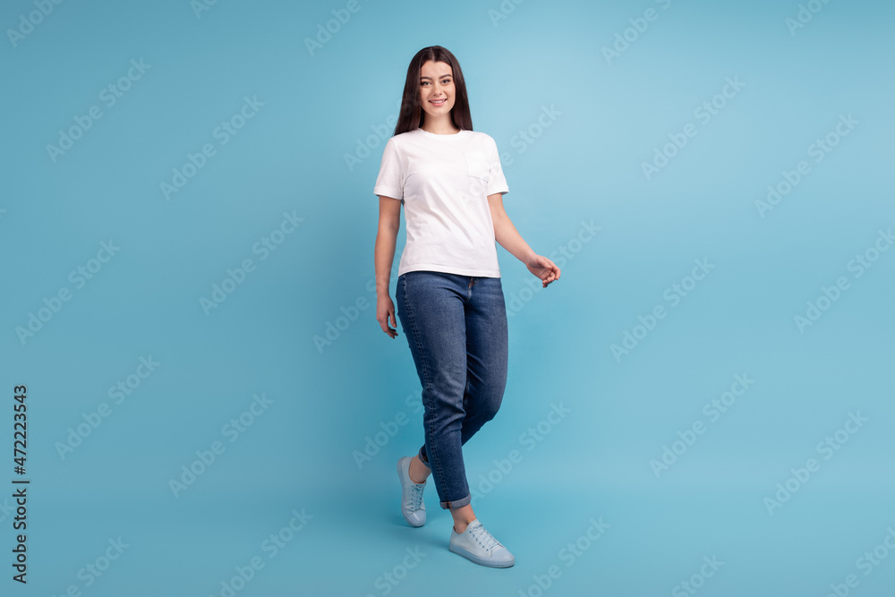 Full size photo of young charming woman good mood walk wear casual clothes isolated over blue color background
