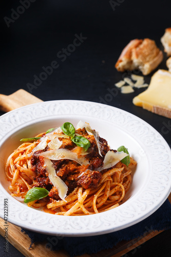 Food concept Homemade pasta Linguine meat bolognese sauce in a white ceramic pasta bowl on wooden board with black slate stone for copy space
