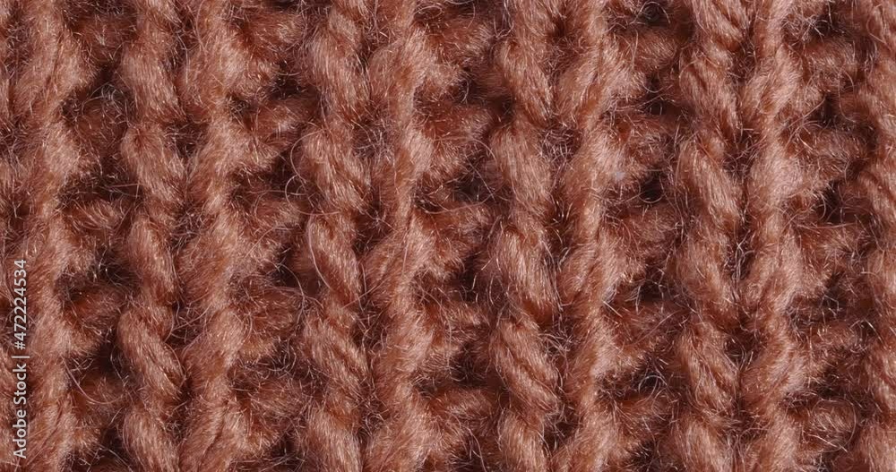 The texture of the knitted part is close-up. Macro fragment. Terracotta background. The texture of the knitted part is close-up. Macro fragment. Terracotta background.