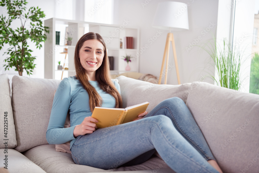 Photo portrait young woman laying on couch reading book relaxing at home Photo portrait young woman laying on couch reading book relaxing at home
