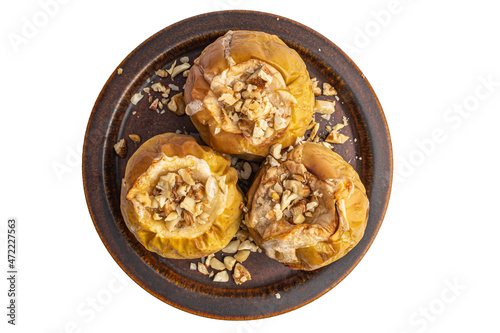 baked apples with nuts on a ceramic brown plate, top view