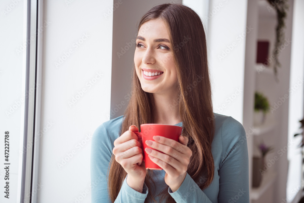 Profile side photo of young cheerful girl happy positive smile drink mug coffee tea morning look window dreamy indoors Profile side photo of young cheerful girl happy positive smile drink mug coffee tea morning look window dreamy indoors
