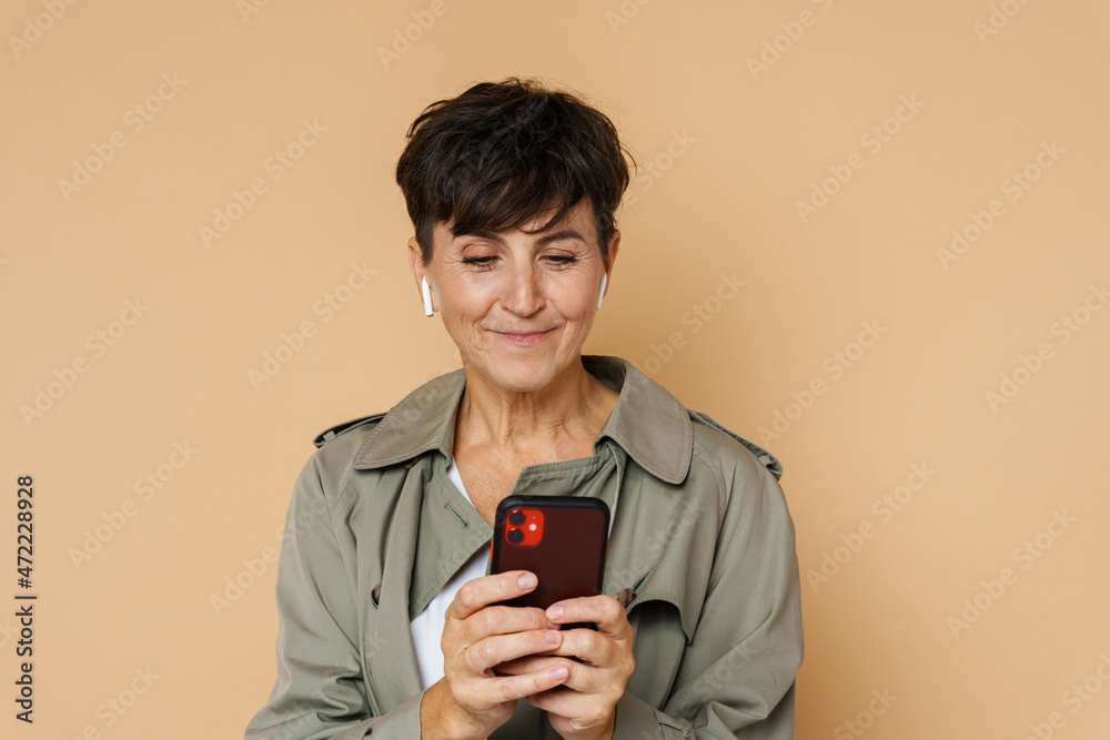 Mature european woman in earphones laughing and looking upwards Mature european woman in earphones laughing and looking upwards