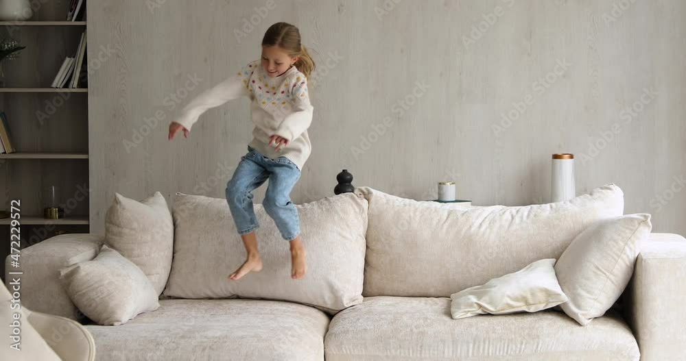 Naughty child. Overjoyed little girl having fun jump on soft couch at living room call parent brother sister to join her. Energetic junior school age kid dance play funny active game on sofa at home