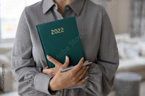 Close Up Of Woman Holding New Year 2022 Diary At Home © Daisy Daisy