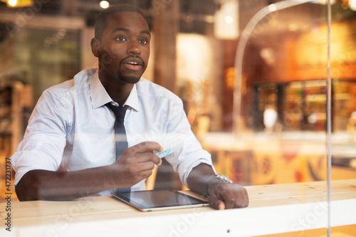 Businessman in cafe holding a credit card. Guy making online payment. Man paying the bill in cafe with a credit card.