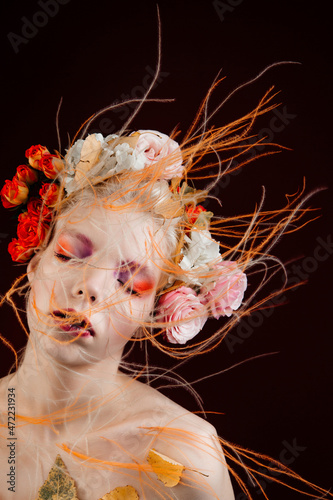 Fototapeta Naklejka Na Ścianę i Meble -  A girl with lively curly hair and flowers in her head. Art object. Flower Fairy