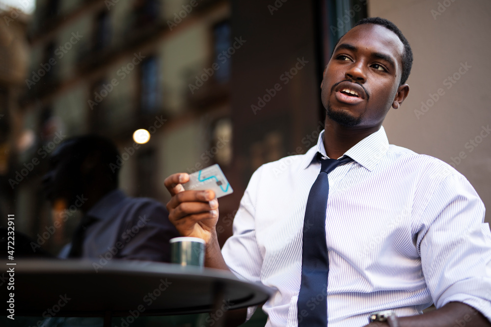 Businessman in cafe holding a credit card. Guy making online payment. Man paying the bill in cafe with a credit card.