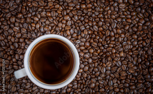 Coffee cup on Coffee beans texture background. Top view