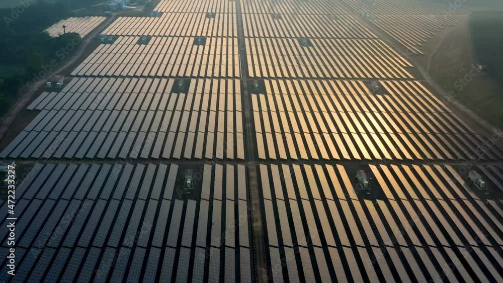 Aerial view of large solar panels at solar farm at sunrise in sunny spring. Solar cell power plants alternative electricity source - concept Aerial view of large solar panels at solar farm at sunrise in sunny spring. Solar cell power plants alternative electricity source - concept
