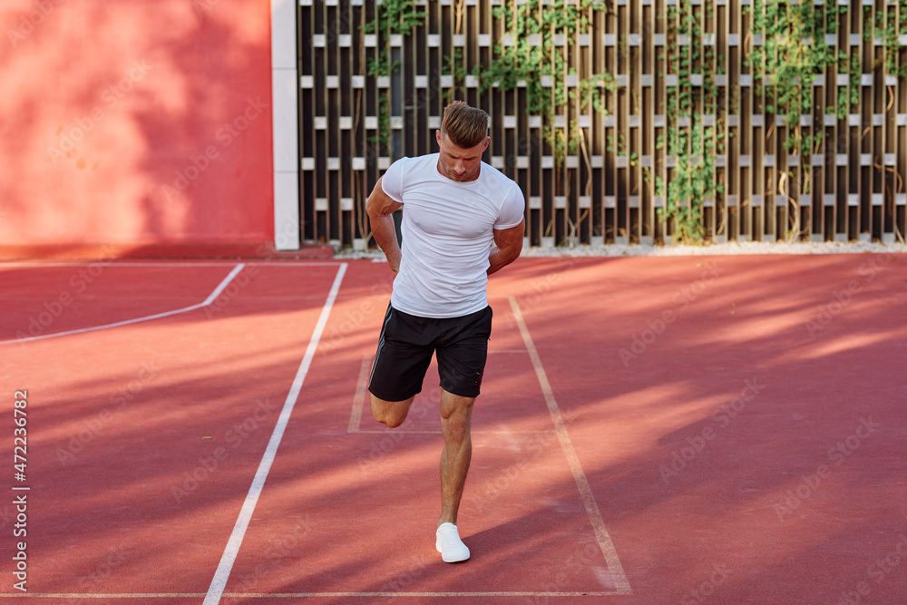 Obraz premium man in white t-shirt on the sports ground workout motivation