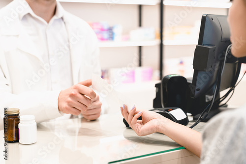 Young female patient client customer buyer giving pharmacist druggist medical prescription while buying drugs pills for insomnia, antidepressants, asking about side effects of medicines in pharmacy