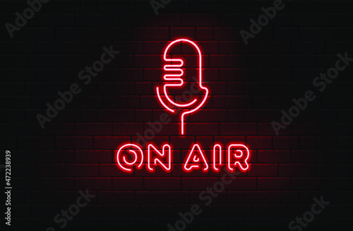 Neon on the air sign with retro microphone on dark brick wall background.