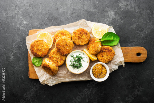 Fish cod potato cakes. Fish fritters with sauces and lemon wedges. Top view