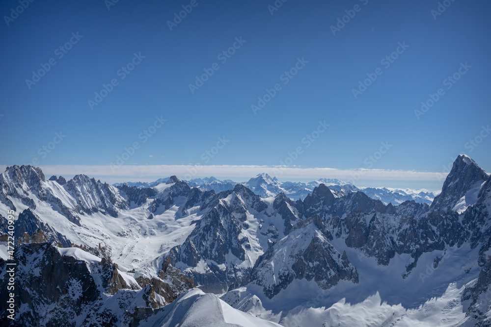 Fototapeta premium A view of the French Alps, Swiss Alps, and Italian Alps on a sunny summer day from the Aiguille du Midi near Mont Blanc in Chamonix, France