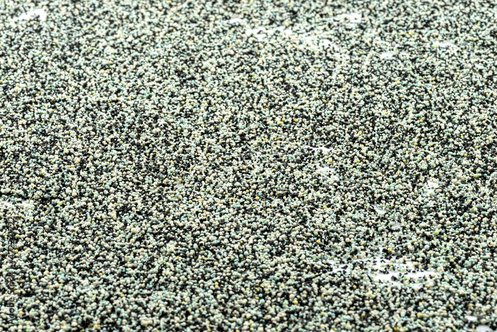 Background made from a macro photo of the inside of the filter with active carbon and water filtration pearls, selective focus in the center. Background made from a macro photo of the inside of the filter with active carbon and water filtration pearls, selective focus in the center.