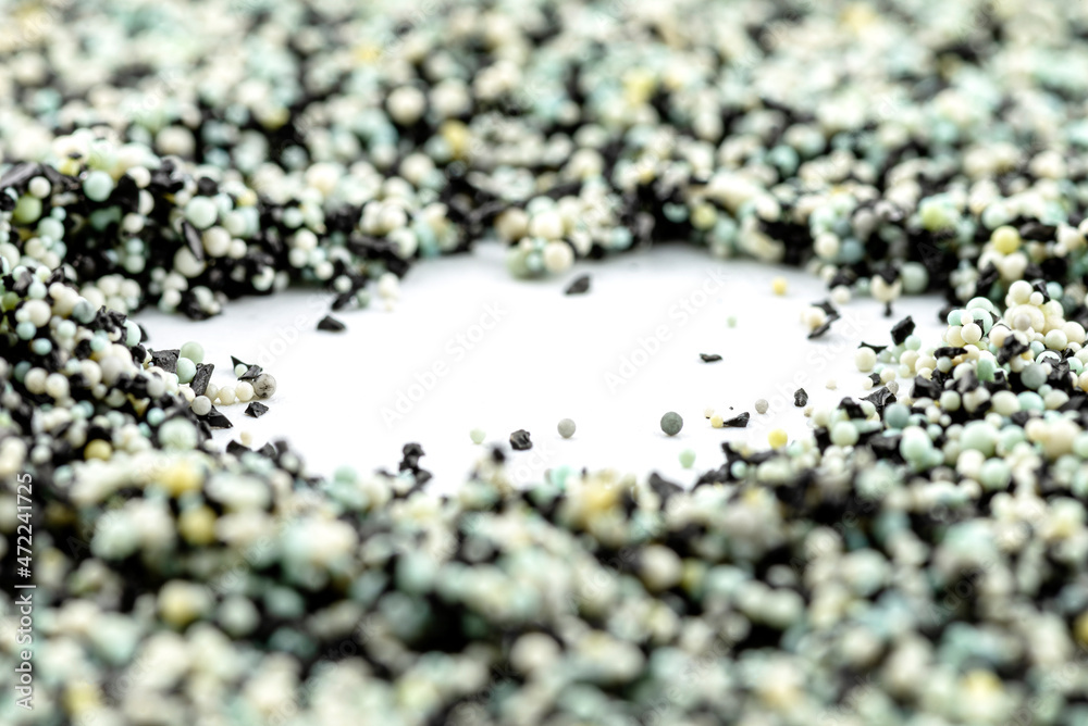 A background made out of strewn inside an activated carbon filter and water filter balls, isolated on a white background, selective focus in the center.